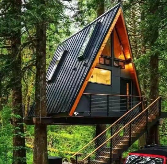 Finnhäuser – Treehouse-A-Frame auf Holzstelzen · Aluminium-Dach · Aufgang über Treppe